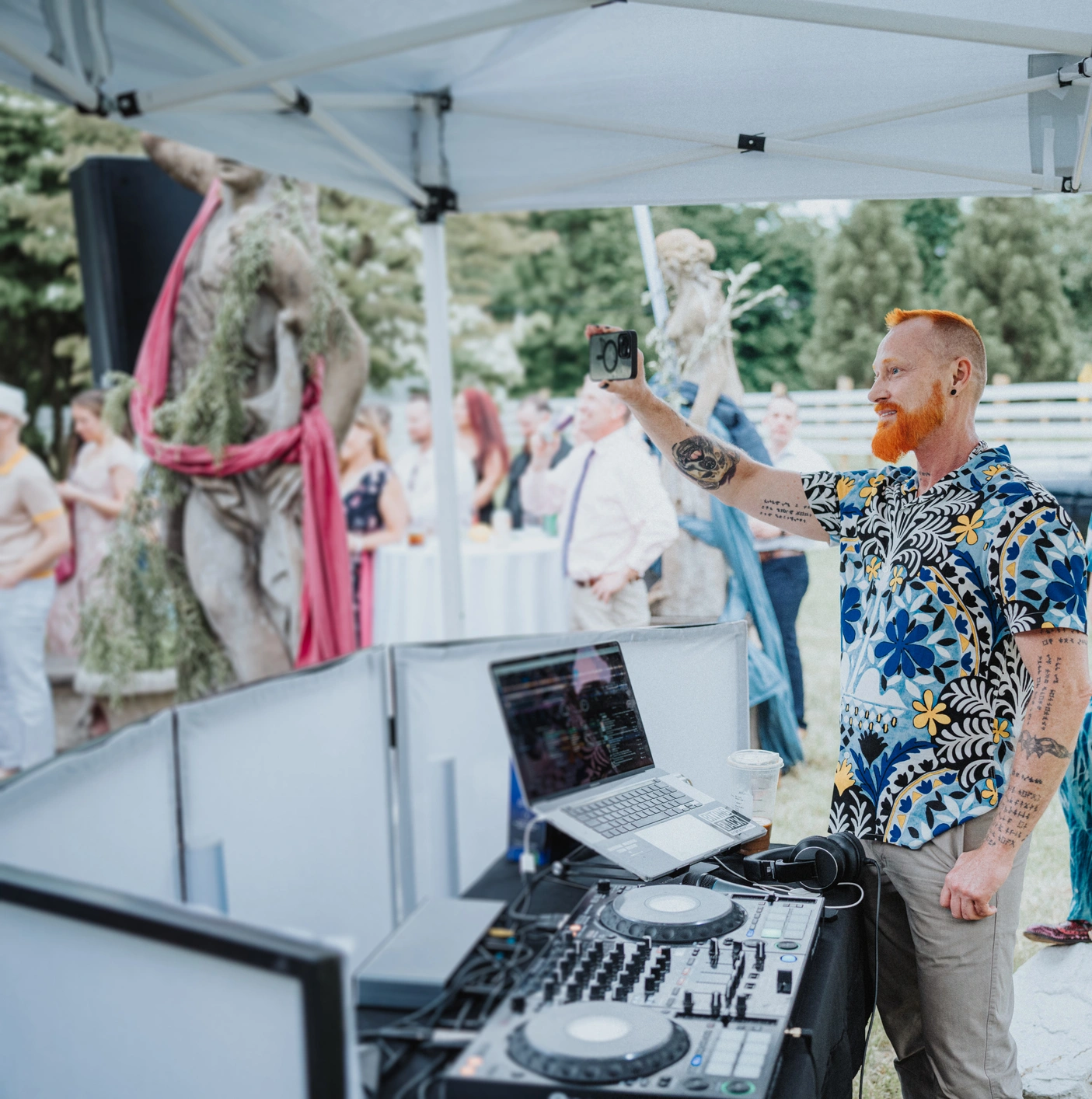 Tattooed DJ with vibrant shirt and laptop