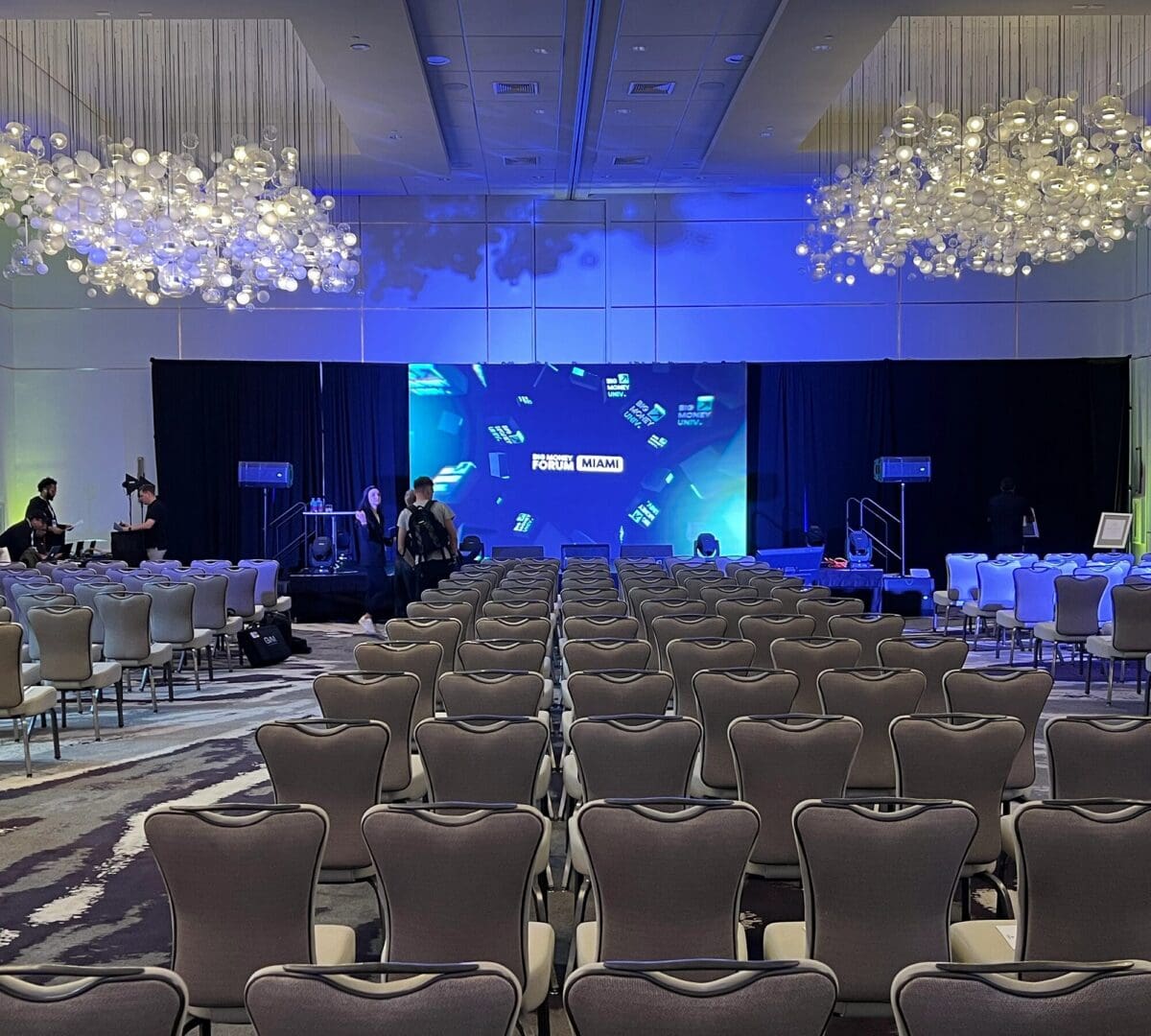 Event setup with chairs and stage backdrop.