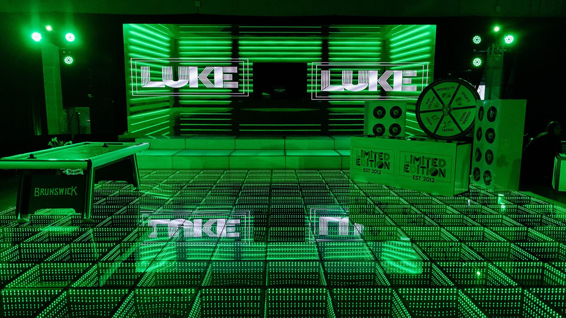 Green-lit stage with illuminated dance floor setup.