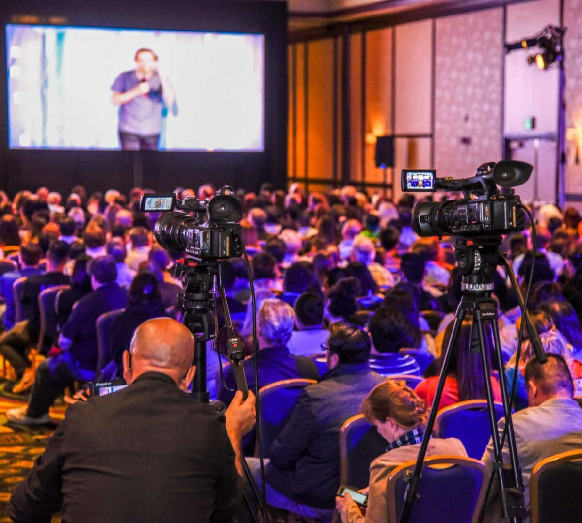 Cameras capturing audience at a live event.