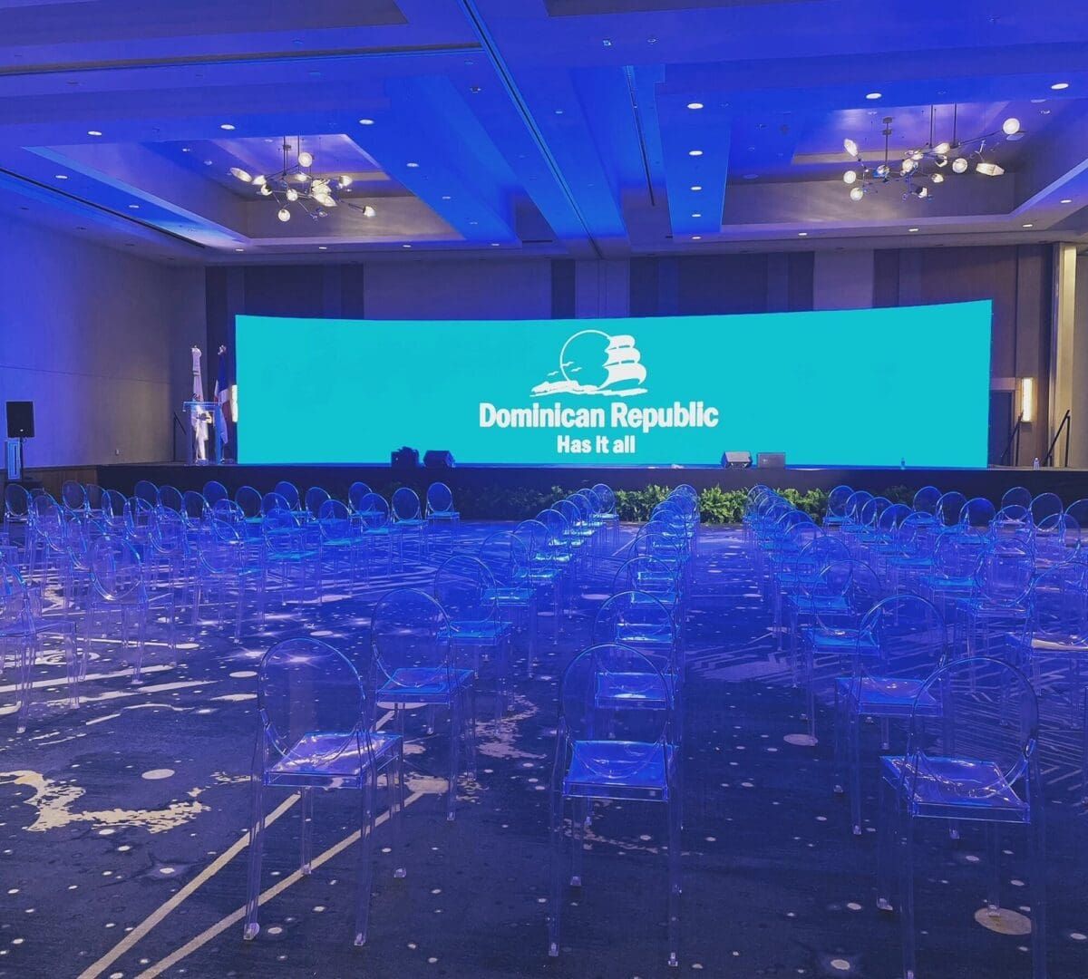 Conference setup with blue lighting and clear chairs.